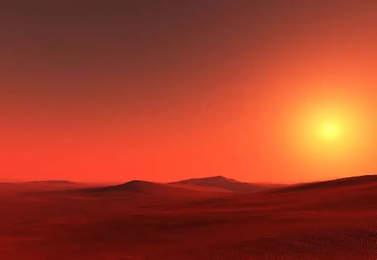 A vast red desert under a low burning sun